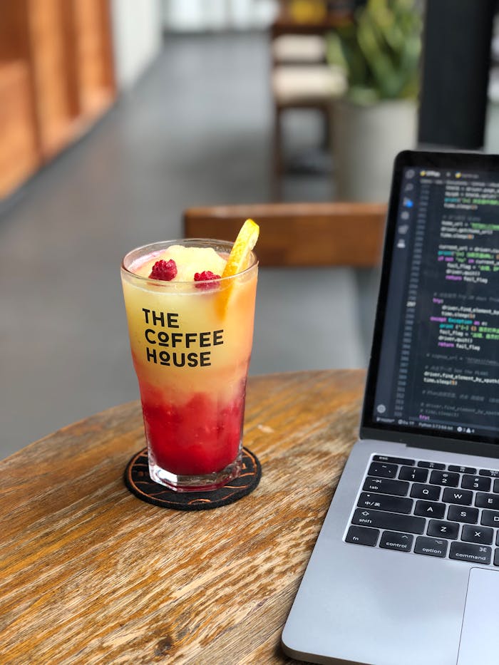 our-services-1 Chilled raspberry lemonade and coding on a laptop at a modern coffee house.